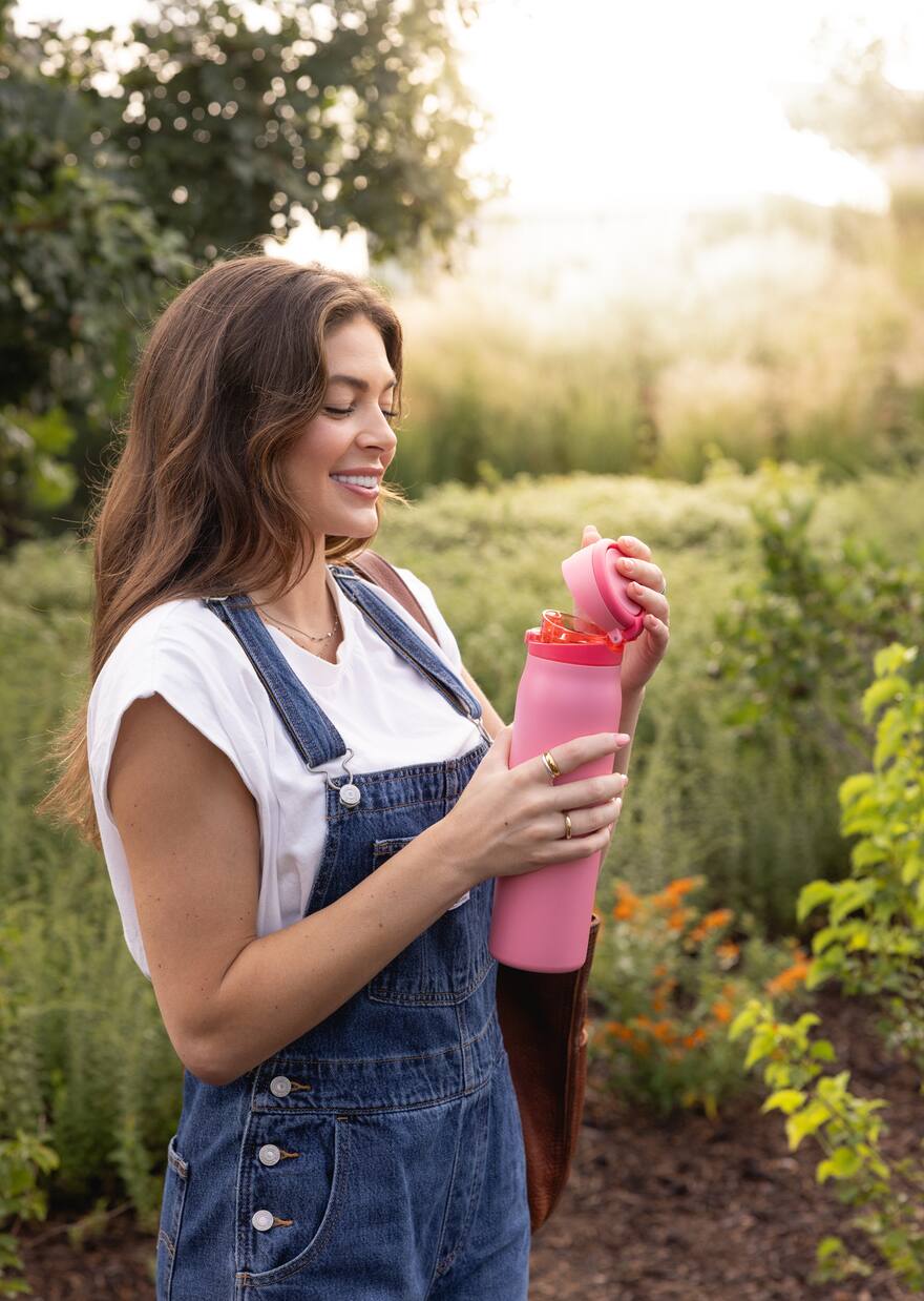 Woman enjoying an insulated water bottle outdoors